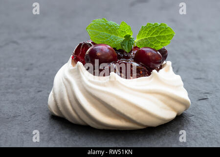 Pavlova  meringue cake with cranberry and mint leaves Stock Photo