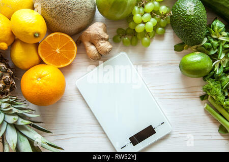 Flat lay composition with kitchen scales, healthy vegetables and fruit on wooden background. Weight loss diet Stock Photo
