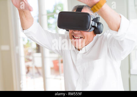 Man wearing virtual reality glasses smiling looking very happy and excited Stock Photo