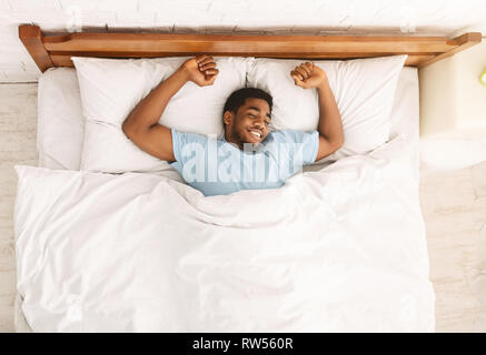 Young african-american man sleeping in bed top view Stock Photo