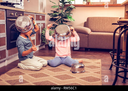Relaxed kids playing at home with kitchenware Stock Photo