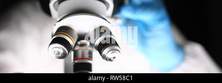 Male chemist in blue protective gloves look Stock Photo