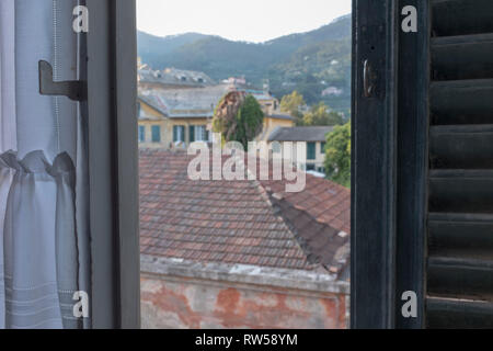 Italian town view from a half opened window with a wooden shutter Stock Photo