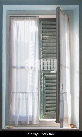 A half open window with shutters viewed from inside Stock Photo