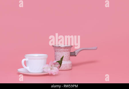 Minimalism style. One cup of coffee and coffee maker on a pink background, coffee turka Stock Photo