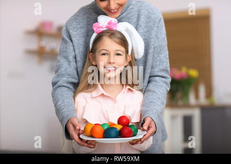 Mother and daughter painting Easter eggs at home Stock Photo