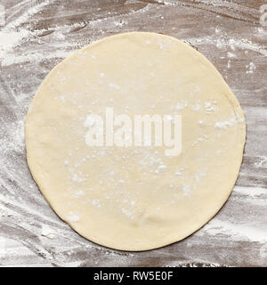 Rolled out pizza dough on floured surface Stock Photo