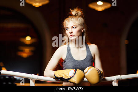 Boxer woman in boxing gloves in ring on black background Stock Photo