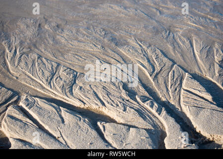 Sand beach resembling a tiny river delta system on a beach with mussel shells Stock Photo