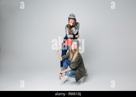 Swag girlfriends hipster in stylish wear and caps on head. Stock Photo