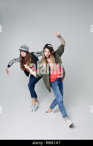 Swag girlfriends hipster in stylish wear and caps on head. Stock Photo