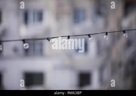 Turned off light bulbs in a row on a cable Stock Photo
