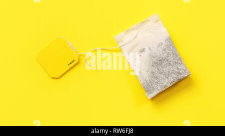 Top view, tea bag with empty label on yellow board. Stock Photo