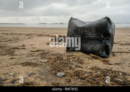 Swansea, UK. 5th March, 2019.  Stormy seas have washed up plastic pollution on to beaches at the Gower peninsula, near Swansea. A large plastic tank measuring a cubic metre was washed ashore at Llangennith beach alongside millions of much smaller items included 'nurdles' which are used in the manufacture of plastic products.  Credit: Gareth Llewelyn/Alamy Live News. Stock Photo