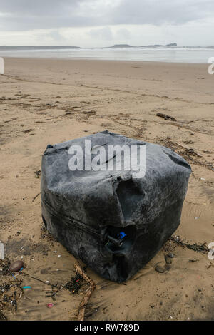 Swansea, UK. 5th March, 2019.  Stormy seas have washed up plastic pollution on to beaches at the Gower peninsula, near Swansea. A large plastic tank measuring a cubic metre was washed ashore at Llangennith beach alongside millions of much smaller items included 'nurdles' which are used in the manufacture of plastic products.  Credit: Gareth Llewelyn/Alamy Live News. Stock Photo