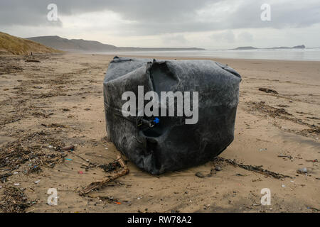 Swansea, UK. 5th March, 2019.  Stormy seas have washed up plastic pollution on to beaches at the Gower peninsula, near Swansea. A large plastic tank measuring a cubic metre was washed ashore at Llangennith beach alongside millions of much smaller items included 'nurdles' which are used in the manufacture of plastic products.  Credit: Gareth Llewelyn/Alamy Live News. Stock Photo