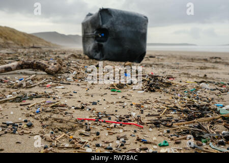 Swansea, UK. 5th March, 2019.  Stormy seas have washed up plastic pollution on to beaches at the Gower peninsula, near Swansea. A large plastic tank measuring a cubic metre was washed ashore at Llangennith beach alongside millions of much smaller items included 'nurdles' which are used in the manufacture of plastic products.  Credit: Gareth Llewelyn/Alamy Live News. Stock Photo