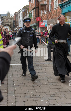 Salisbury, Wiltshire, UK. 5th Mar, 2019. Competitors competing in the annual pancake race on High Street, Salisbury. Community police officer taking part in this community event. Stock Photo