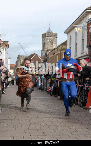 Salisbury, Wiltshire, UK. 5th Mar, 2019. Competitors competing in the annual pancake race on High Street, Salisbury. The event is organised by St Thomas's Church and the Trussell Trust.