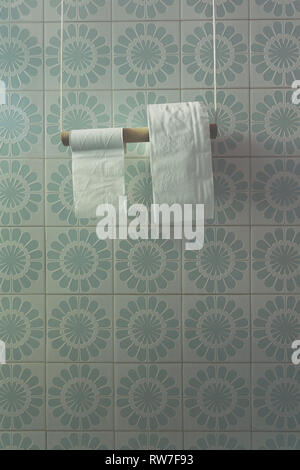 Two rolls of toilet paper on diy holder in a bath, light-blue tiles wall. Soft filtered, faded, vintage Stock Photo