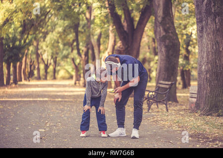 Little boy and his father taking a break and listening to the music together in the park. Father and son spend time together and lead a healthy lifest Stock Photo