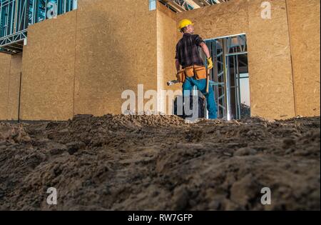 Construction Industry Theme. Caucasian Professional Builder and the Developed Building. Stock Photo