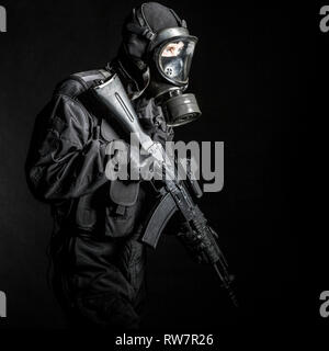 Russian special forces operator in black uniform and gas mask. Stock Photo