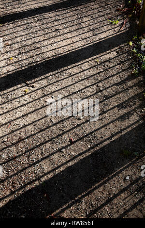 Shadow from fence on dirt ground. Stock Photo