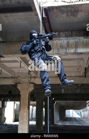 Special forces operator during assault rappelling with weapons. Stock Photo