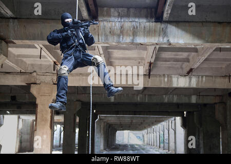 Special forces operator during assault rappelling with weapons. Stock Photo