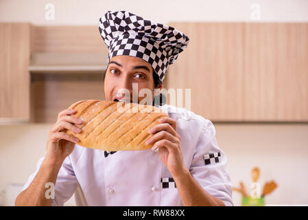 Young male baker working in kitchen Stock Photo