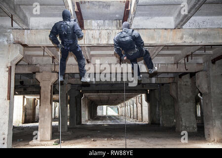 Special forces operators during assault rappelling with weapons. Stock Photo