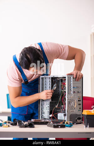 Young male contractor repairing computer Stock Photo