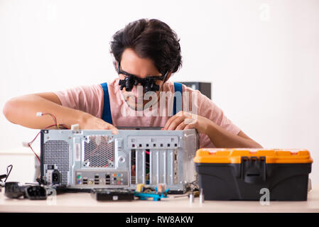 Young male contractor repairing computer Stock Photo