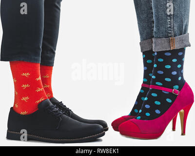 Men's and women's trendy shoes, blue trousers and beautiful, multicolored socks on a white, isolated background. Close-up. Side view. Concept style an Stock Photo