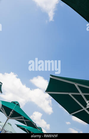 Several umbrellas on the beach against blue sky with clouds in the summer.shore ocean .Concept of tourism travel.body skin protection from melanoma Stock Photo