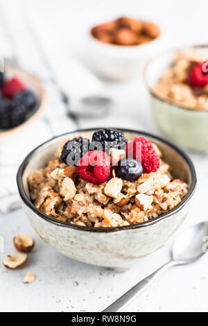 Oatmeal porridge with berries, seeds and nuts in bowl. Healthy breakfast, vegan or vegetarian diet, weight loss, paleo food concept Stock Photo