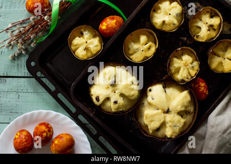 Preparation for baking, Easter raw bread. Easter cake and painted eggs on wooden table in rustic style. Stock Photo