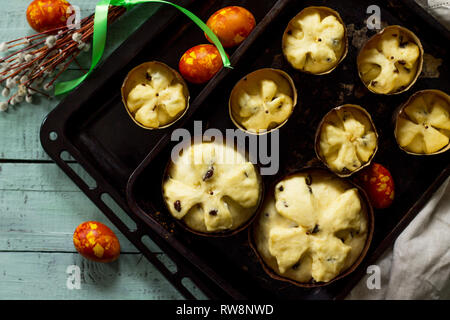 Preparation for baking, Easter raw bread. Easter cake and painted eggs on wooden table in rustic style. Stock Photo