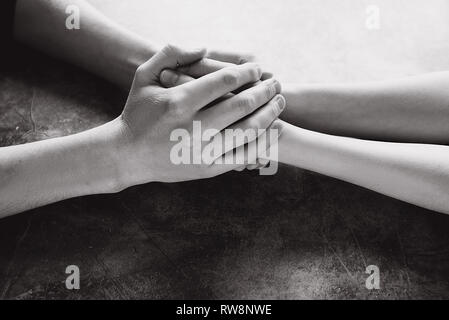Close up view of couple holding hands to take care and help each other. Help and sharing ideas Stock Photo