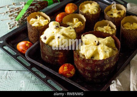 Preparation for baking, Easter raw bread. Easter cake and painted eggs on wooden table in rustic style. Copy space. Stock Photo