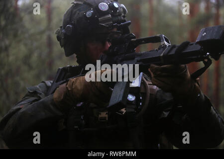 A U.S. Marine with Special Purpose Marine Air-Ground Task Force-Crisis Response-Africa 19.1, Marine Forces Europe and Africa, holds security with a German G36 rifle during a bilateral training exercise with the Fallschirmjäger Regiment-31 (31st Paratrooper Regiment) at a German military training facility in Lehnin, Germany, Feb. 10, 2019. SPMAGTF-CR-AF is deployed to conduct crisis-response and theater-security operations in Europe and Africa. (U.S. Marine Corps photo by 1st Lt. Christin St. John) Stock Photo