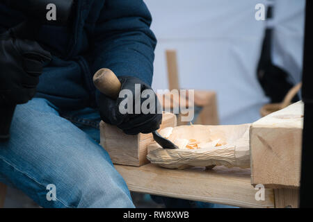 Close up of hands of craftsman carve with a gouge in the hands on the workbench in carpentry Stock Photo