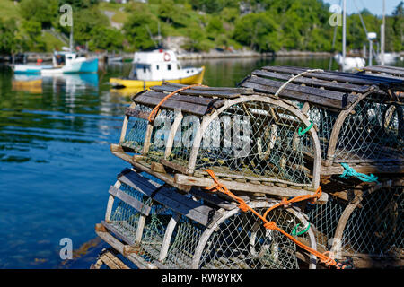 Stacks of traditional wooden lobster traps on the wharf in a Nova Scotia fishing village. Stock Photo