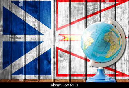 Globe with a world map on a wooden background with the image of the flag of Newfoundland and Labrador. The concept of travel and leisure abroad. Stock Photo