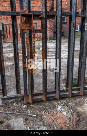 A rusty chain with an open lock at the end of the chain Stock Photo