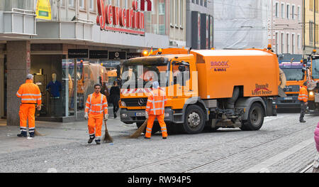 Wurzburg, Germany - 3 March 2019: workers cleaning dirty roads and city with automated cleaning trucks after the events of Fasching cultural carnival. Stock Photo