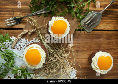 Easter cupcake on wooden background with Peach looks like a fried egg Stock Photo