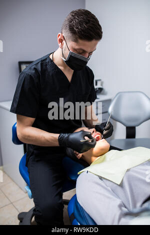 Dentist examines the teeth of the patient on the dentist's chair Stock Photo