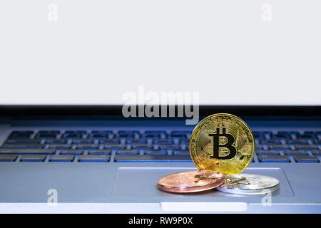 Bitcoin coins on laptop computer track pad Stock Photo